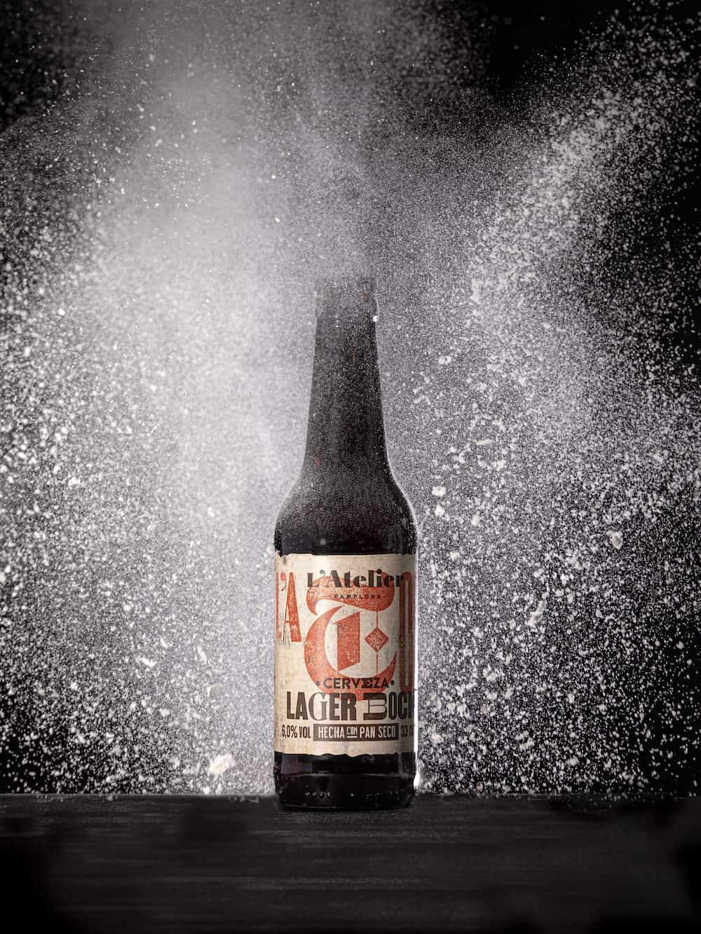 Imagen de una cerveza y detalle del diseño de la etiqueta de Cervezas L'Atelier con la tipografía corporativa Drunken Master