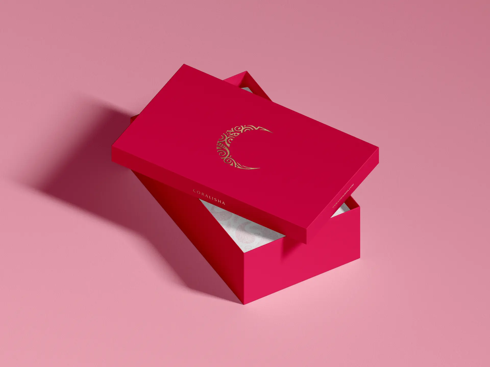 caja de zapatos roja sobre fondo rosa con logotipo marca coralisha estampado en dorado