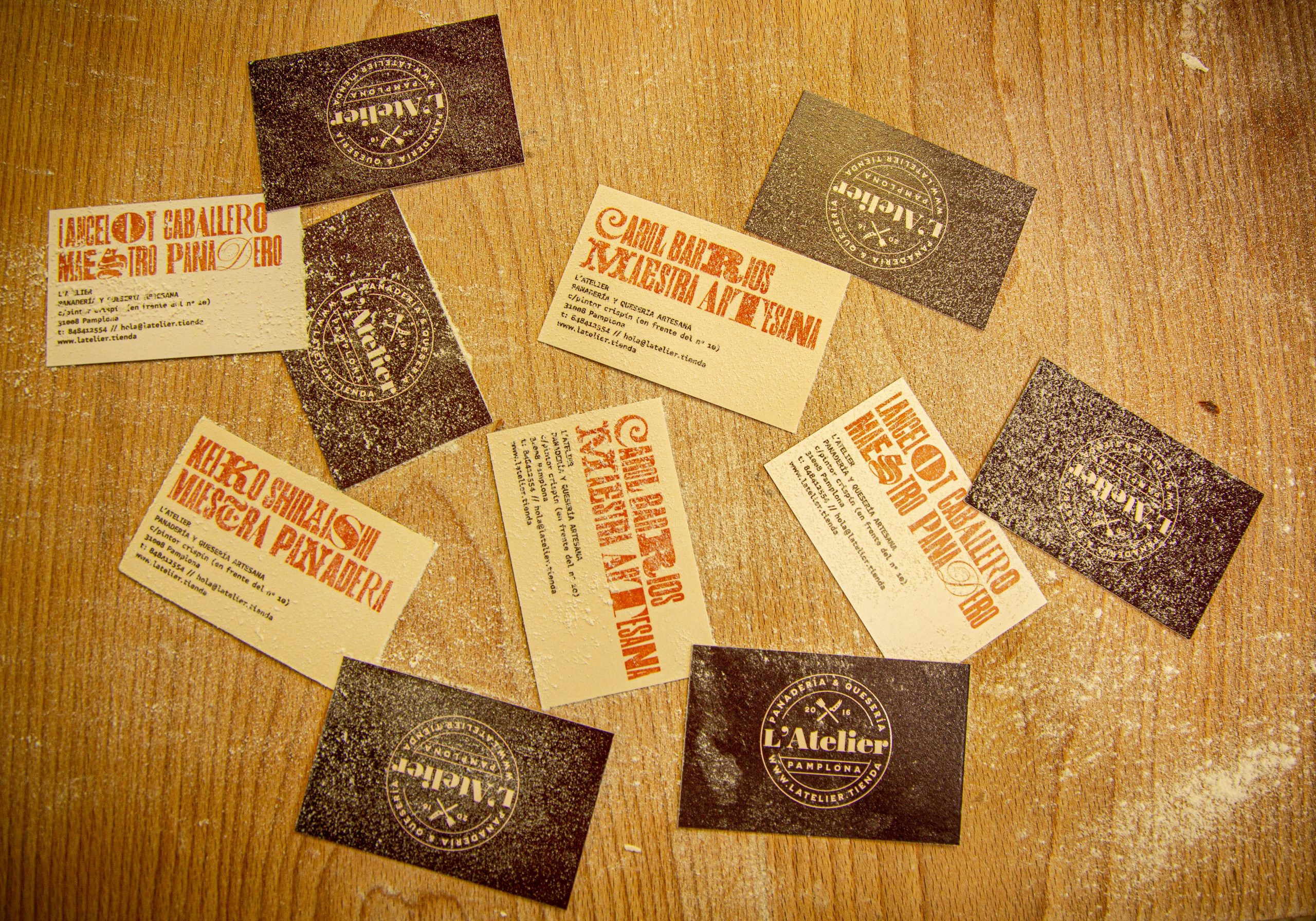 Imagen cenital de las tarjetas impresas de L'Atelier con la tipografía corporativa Drunken Master.